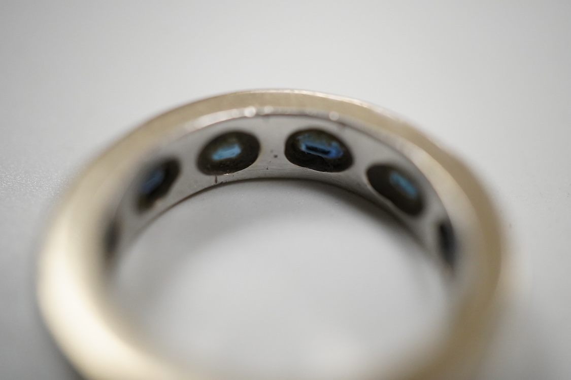 A recent Italian white metal (stamped 750) and seven stone gypsy set oval cut sapphire band, by Cristiano of Genoa, size N, gross weight 10.4 grams.